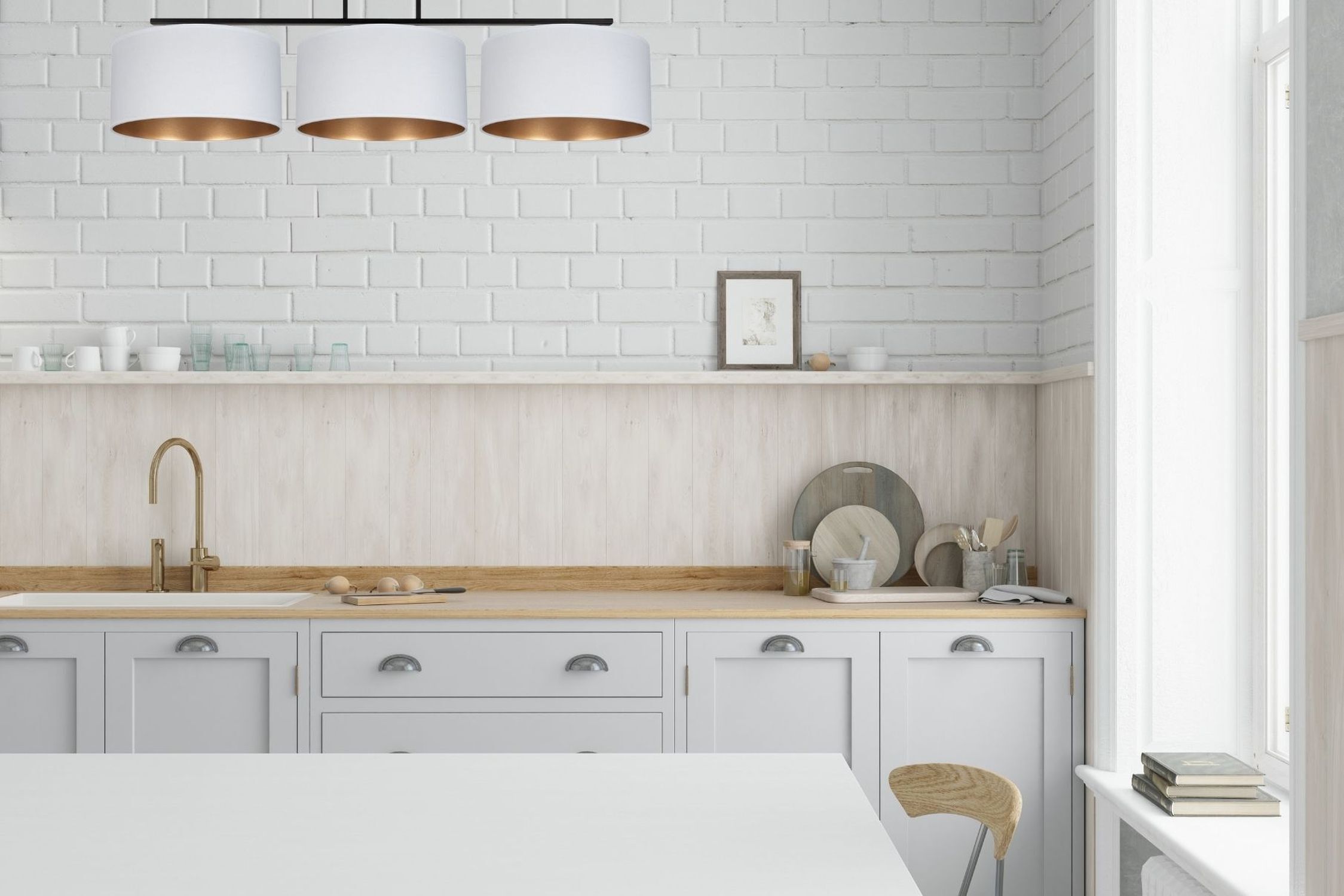 Küche, hellgraue Schränke, weiße Ziegelwand, Holzarbeitsplatte, Messingarmatur