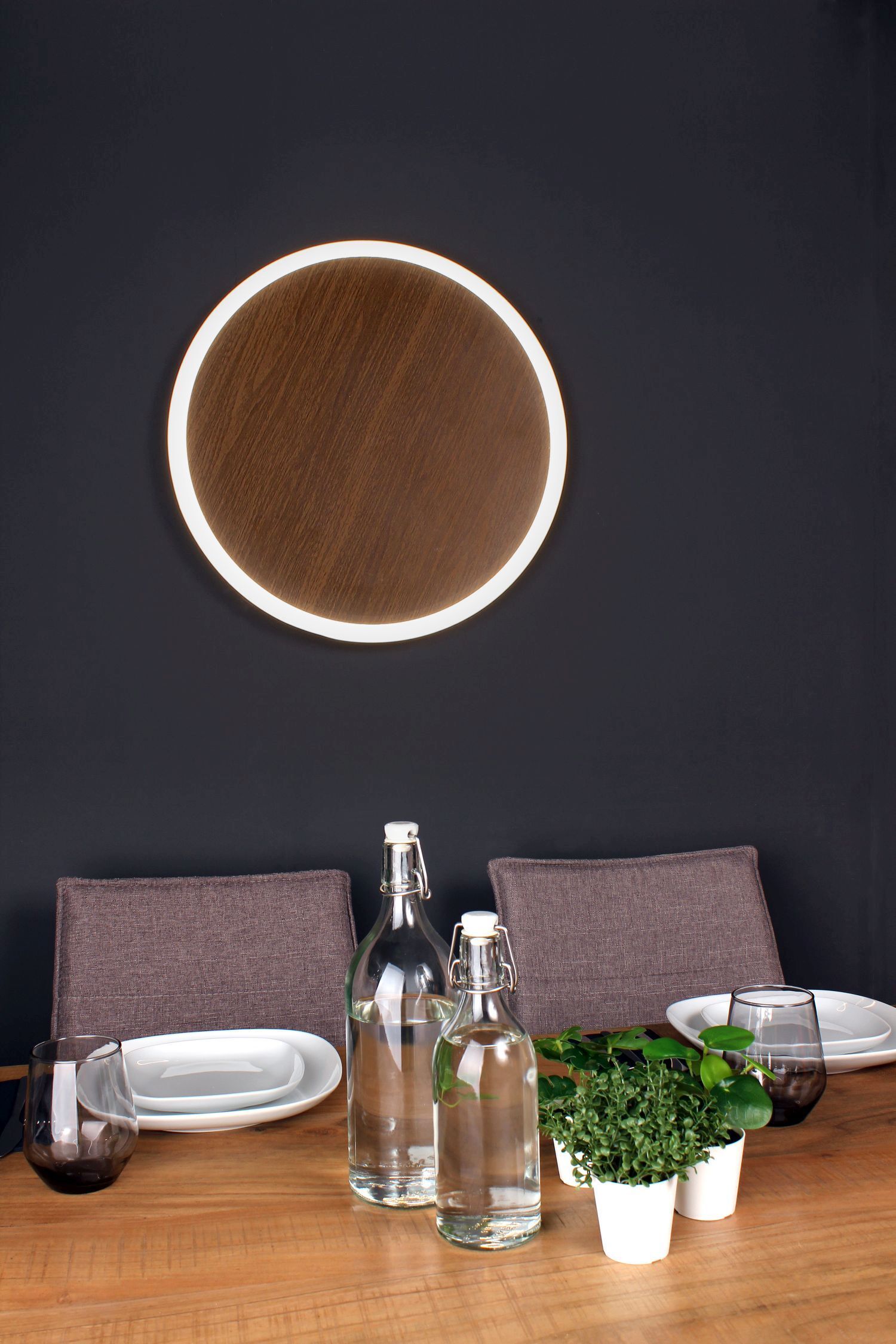 LED Wandleuchte Holz Schwarz rund Ø50 cm 3500 K dimmbar Wandleuchte, runder Spiegel, Holztisch, Glasflaschen, kleine Topfpflanze